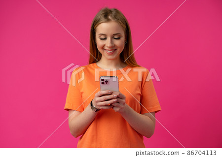 Portrait of a young woman using mobile phone over color background. 86704113