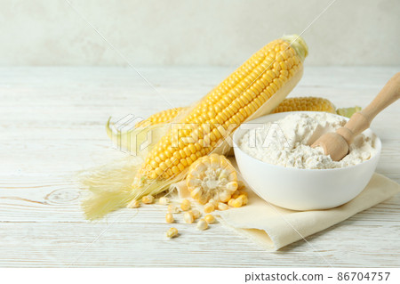 Raw corn and flour on white wooden table Raw corn and flour on white wooden table 86704757