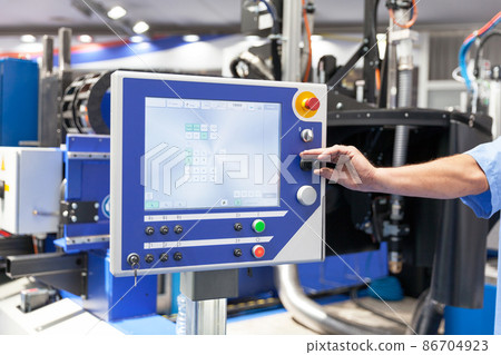 Man working at programmable computer numerical control - CNC machine Man working at programmable computer numerical control - CNC machine 86704923
