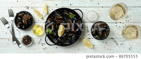 Concept of delicious food with mussels on white wooden table Concept of delicious food with mussels on white wooden table 86705553