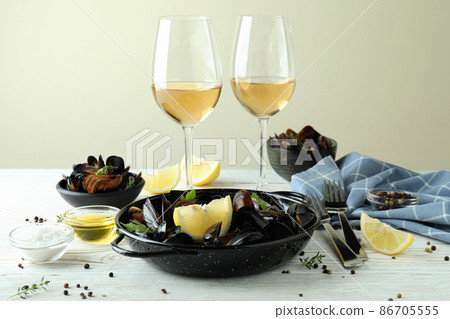 Concept of delicious food with mussels on white wooden table Concept of delicious food with mussels on white wooden table 86705555