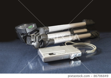 Camera and tripod on a glass table with reflection 86706849