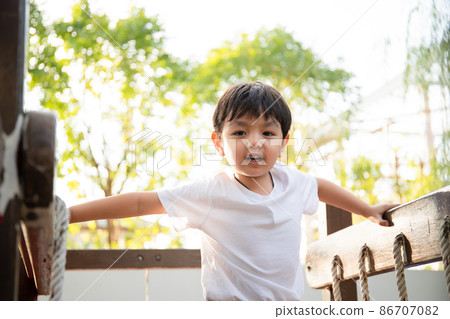 Happy Asian little boy enjoy playing and walking at the park with daddy close up, Asian boy have a beautiful smiling while looking at his father. Little boy portrait at the park and playground. Happy Asian little boy enjoy playing and walking at the park with daddy close up, Asian boy have a beautiful smiling while looking at his father. Little boy portrait at the park and playground. 86707082