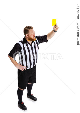 Warning. Dynamic portrait of soccer or football referee running with card isolated on white studio background. Concept of sport, rules, competitions, rights, ad, sales. 86707172