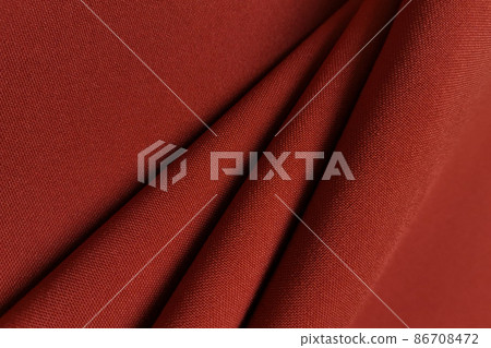 Red crumpled or wavy fabric texture background. Abstract linen cloth soft waves. Gabardine wool fabric. Merino yarn. Smooth elegant luxury cloth texture. Concept for banner or advertisement. Red crumpled or wavy fabric texture background. Abstract linen cloth soft waves. Gabardine wool fabric. Merino yarn. Smooth elegant luxury cloth texture. Concept for banner or advertisement. 86708472