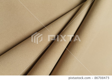 Gold crumpled or wavy fabric texture background. Golden abstract linen cloth soft waves. Gabardine wool fabric. Merino yarn. Smooth elegant luxury cloth texture. Concept for banner or advertisement. Gold crumpled or wavy fabric texture background. Golden abstract linen cloth soft waves. Gabardine wool fabric. Merino yarn. Smooth elegant luxury cloth texture. Concept for banner or advertisement. 86708473