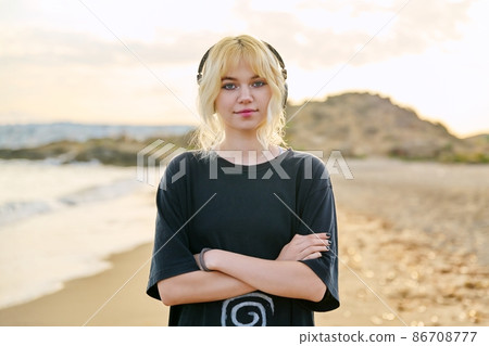 Confident smiling teenage female with crossed arms looking at camera Confident smiling teenage female with crossed arms looking at camera 86708777