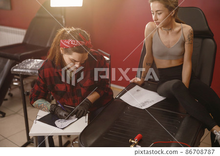 Focused tattoo artist in shirt drawing sketch Focused tattoo artist in shirt drawing sketch 86708787