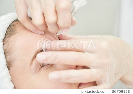 Injection at spa salon. Doctor hands in gloves. Closeup. Pretty female patient 86709138