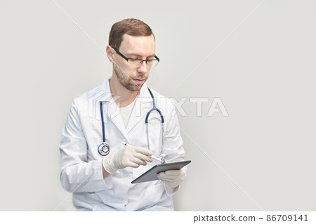 Doctor using tablet. Hospital electronic device. Online patient examination Doctor using tablet. Hospital electronic device. Online patient examination 86709141