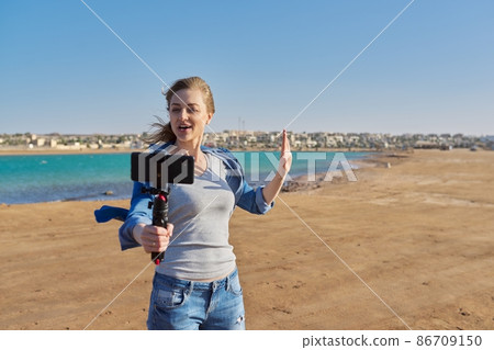 Mature woman recording video on smartphone, making a stream Mature woman recording video on smartphone, making a stream 86709150
