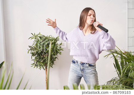 Young woman sing at home. Karaoke black microphone. House lyrics dance. Young woman sing at home. Karaoke black microphone. House lyrics dance. 86709183