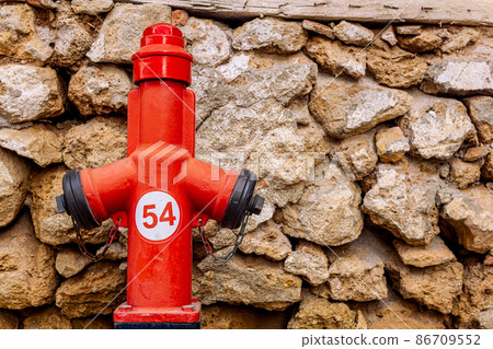 fire hydrant near vintage stone wall 86709552
