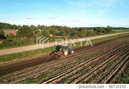 Tractor with Plough on Plowed. Ploughing and Soil Tillage. Tractor with Plough on Plowed. Ploughing and Soil Tillage. 86710142