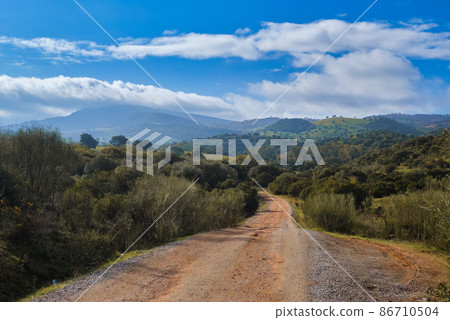 Rural road leading to the mountain range. Spain 86710504