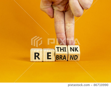 Rethink and rebrand symbol. Businessman turns cubes and changes the word 'rethink' to 'rebrand'. Beautiful orange background. Business, rethink and rebrand concept. Copy space. 86710990