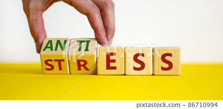 Antistress vs stress symbol. Doctor turns cubes and changes the word stress to anti stress. Beautiful white table, white background. Medical, psychological, antistress vs stress concept. Copy space. Antistress vs stress symbol. Doctor turns cubes and changes the word stress to anti stress. Beautiful white table, white background. Medical, psychological, antistress vs stress concept. Copy space. 86710994