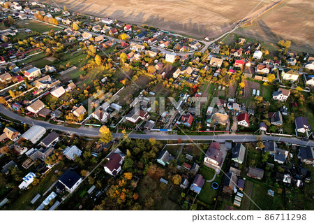 Country houses in the countryside. Aerial view of roofs of green field with rural homes.  86711298