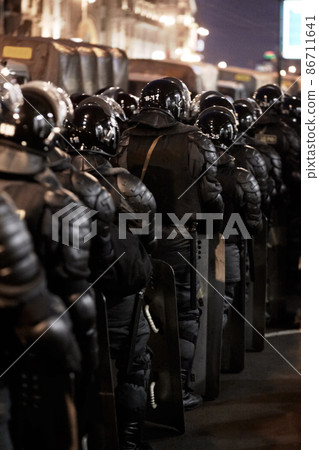 Soldiers stick together. The army barricading a riot in the city. Soldiers stick together. The army barricading a riot in the city. 86711641
