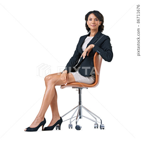 Dreaming of her corporate ambitions. Studio portrait of a successful businesswoman sitting on a chair against a white background. Dreaming of her corporate ambitions. Studio portrait of a successful businesswoman sitting on a chair against a white background. 86711676