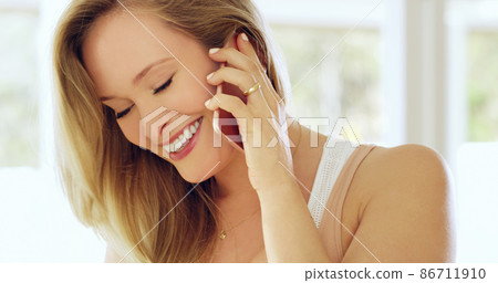 Carefree and connected. Cropped shot of an attractive young woman making a call on a cellphone at home. 86711910
