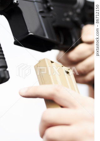 Rifle reload. Closeup on a soldier's hand reloading ammunition into a gun. Rifle reload. Closeup on a soldier's hand reloading ammunition into a gun. 86712150
