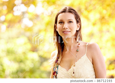 Autumn beauty. Shot of an attractive young woman in the park on an autumn day. 86712193