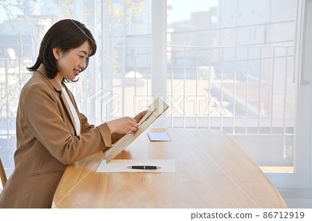 A woman opening a ball string envelope at a desk 86712919