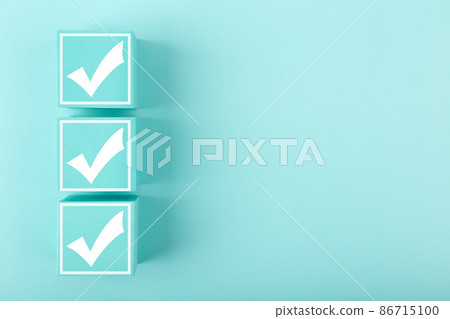 Three white checkmarks on blue cubes against bright pastel blue background with copy space Three white checkmarks on blue cubes against bright pastel blue background with copy space 86715100