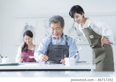 在一所文化學校參加水彩畫班的高級男女教師 86717292