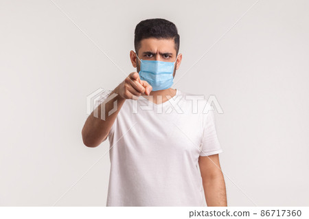 Hey you, use filters against novel influenza. Man pointing at camera and wearing hygienic mask to prevent coronavirus infection, respiratory diseases such as 2019-nCoV, ebola. studio shot, isolated Hey you, use filters against novel influenza. Man pointing at camera and wearing hygienic mask to prevent coronavirus infection, respiratory diseases such as 2019-nCoV, ebola. studio shot, isolated 86717360