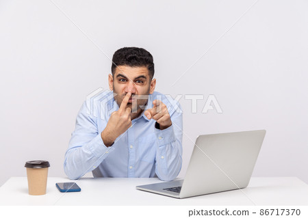 You are telling lie. Angry businessman sitting office workplace with laptop, touching nose showing liar gesture, suspecting falsehood. Body language, indoor studio shot isolated on white background You are telling lie. Angry businessman sitting office workplace with laptop, touching nose showing liar gesture, suspecting falsehood. Body language, indoor studio shot isolated on white background 86717370
