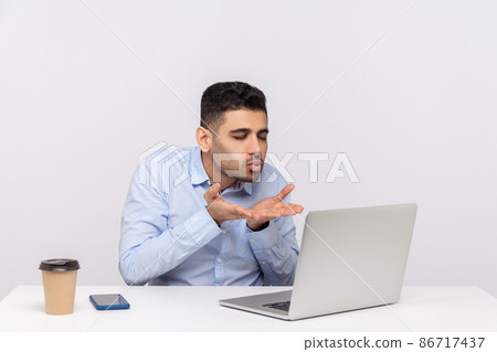 Love you. Handsome elegant businessman sitting office workplace, sending air kiss to laptop screen, talking on video call, expressing romantic feelings. indoor studio shot isolated on white background Love you. Handsome elegant businessman sitting office workplace, sending air kiss to laptop screen, talking on video call, expressing romantic feelings. indoor studio shot isolated on white background 86717437