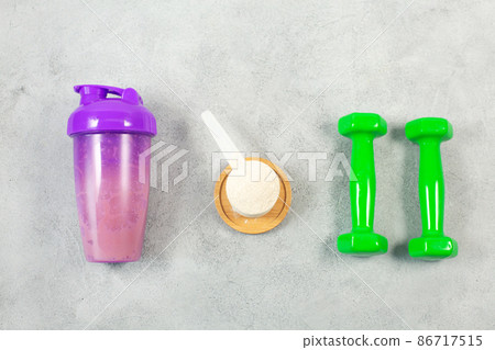 Shaker, dumbbells and Measuring scoop of protein powder on gray concrete background Shaker, dumbbells and Measuring scoop of protein powder on gray concrete background 86717515
