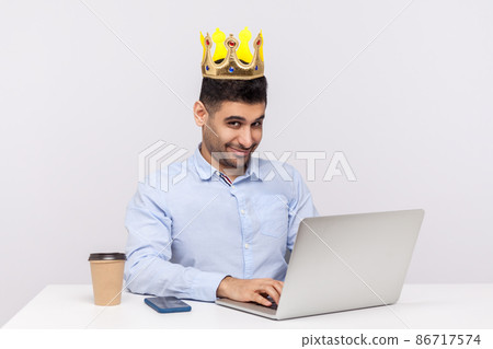 I'm boss. Positive ambitious top manager, office employee with crown on head working on laptop and smiling at camera, feeling proud happy of his position at work. studio shot isolated white background I'm boss. Positive ambitious top manager, office employee with crown on head working on laptop and smiling at camera, feeling proud happy of his position at work. studio shot isolated white background 86717574