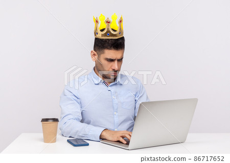 I'm boss. Ambitious arrogant top manager, office employee with crown on head working on laptop and frowning bossy, feeling proud of his position at work. studio shot isolated on white background 86717652