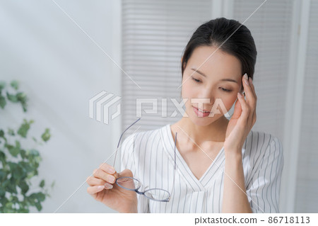 Female holding her head in her thirties Female holding her head in her thirties 86718113