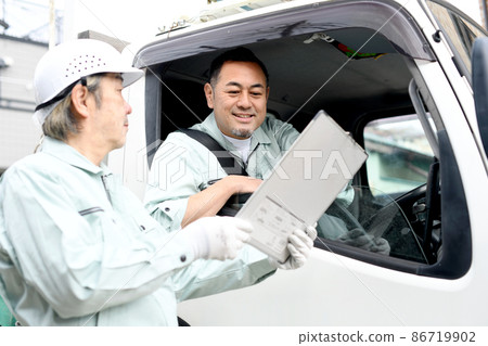 Middle men in work clothes riding on a truck to have a conversation 86719902