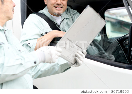 穿著工作服的中間人騎著卡車交談 86719903