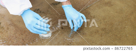 Scientist in protective suit and gloves taking test tube from lake closeup 86722765