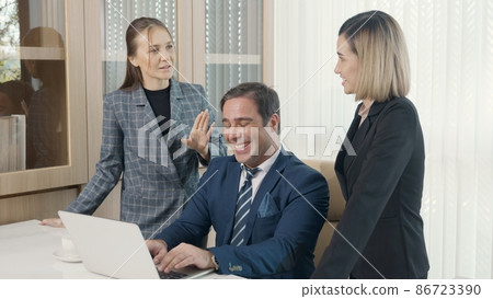Group of young business people working on desk together with one laptop in office 86723390