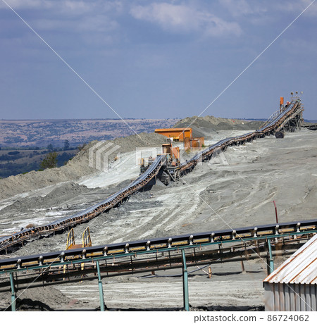 View of the ground conveyor for sorting rocks and raw materials at the mining enterprise. View of the ground conveyor for sorting rocks and raw materials at the mining enterprise. 86724062
