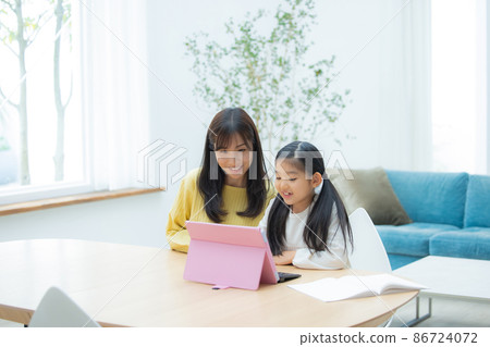 Elementary school students and moms studying on tablets 86724072