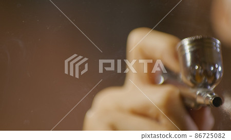 Woman artist learns to paint with airbrush with acrylic dye, paper and easel. Concept modern art, airbrushing, aerography, graffiti, aerosol spray Woman artist learns to paint with airbrush with acrylic dye, paper and easel. Concept modern art, airbrushing, aerography, graffiti, aerosol spray 86725082