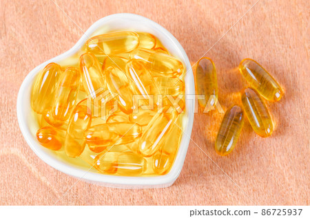 Heart-shape plate with fish oil capsules. Heart-shape plate with fish oil capsules. 86725937