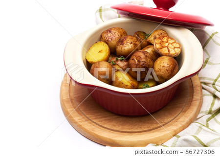 Baked potato in a clay pot isolated on white background Baked potato in a clay pot isolated on white background 86727306