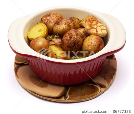 Baked potato in a clay pot isolated on white background 86727328