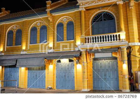 Yellow retro building at night. 86728769