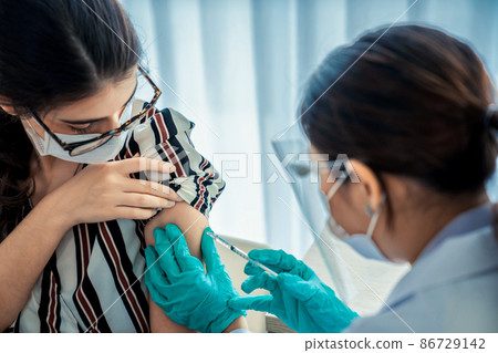 Young woman visits skillful doctor at hospital for vaccination 86729142