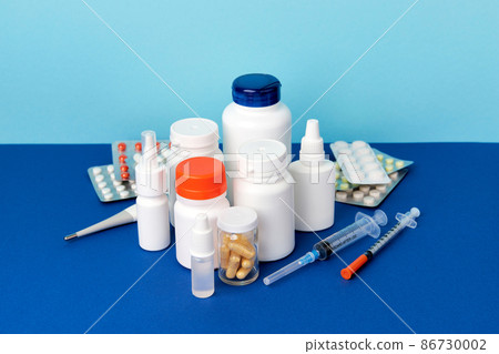 Different medicine pills on blue table. Healthcare pharmacy and medicine concept Different medicine pills on blue table. Healthcare pharmacy and medicine concept 86730002